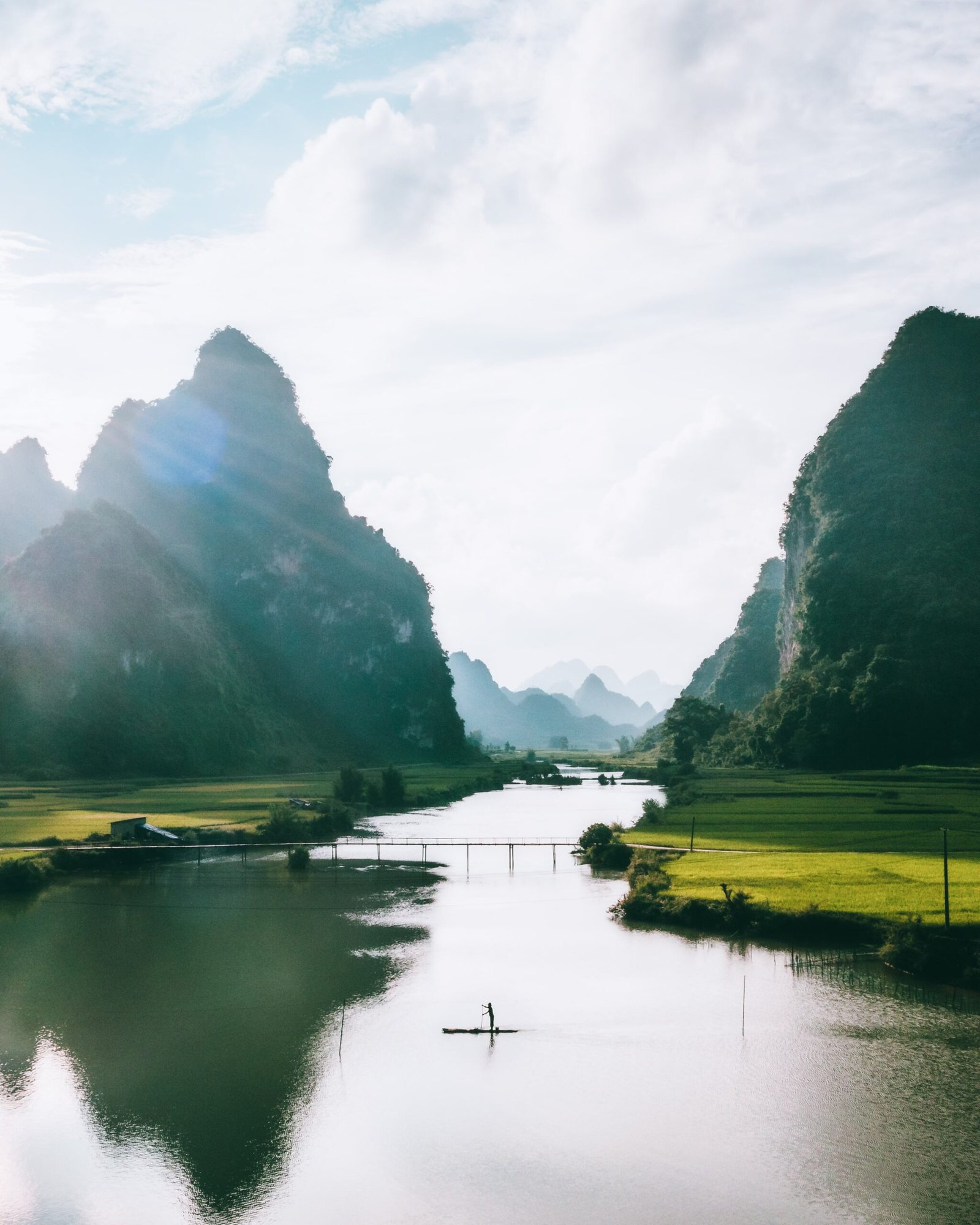 Drone shot of a man crossing a river with his boat in Cao Bang, Vietnam