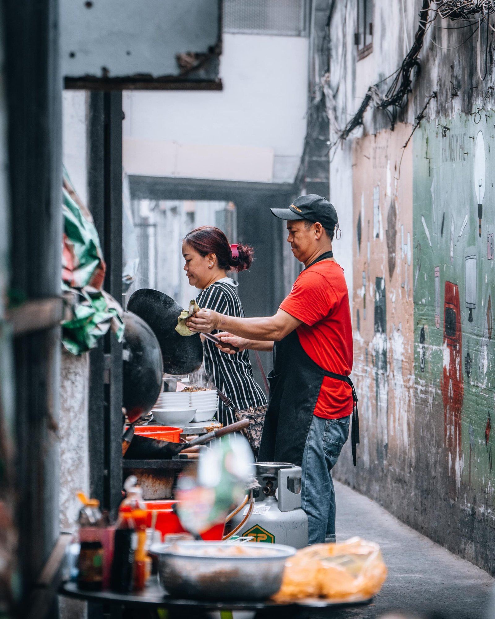 2 people cooking at a street restaurant in Saigon
