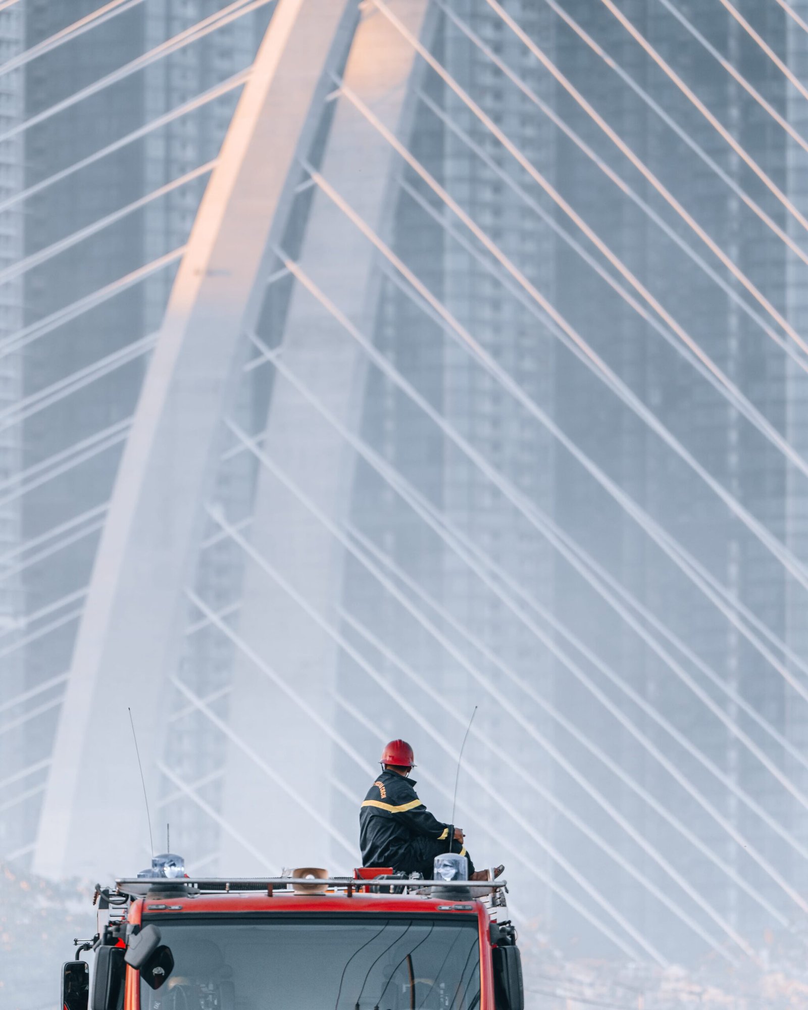 Photo of a fireman on a truck looking at a bridge