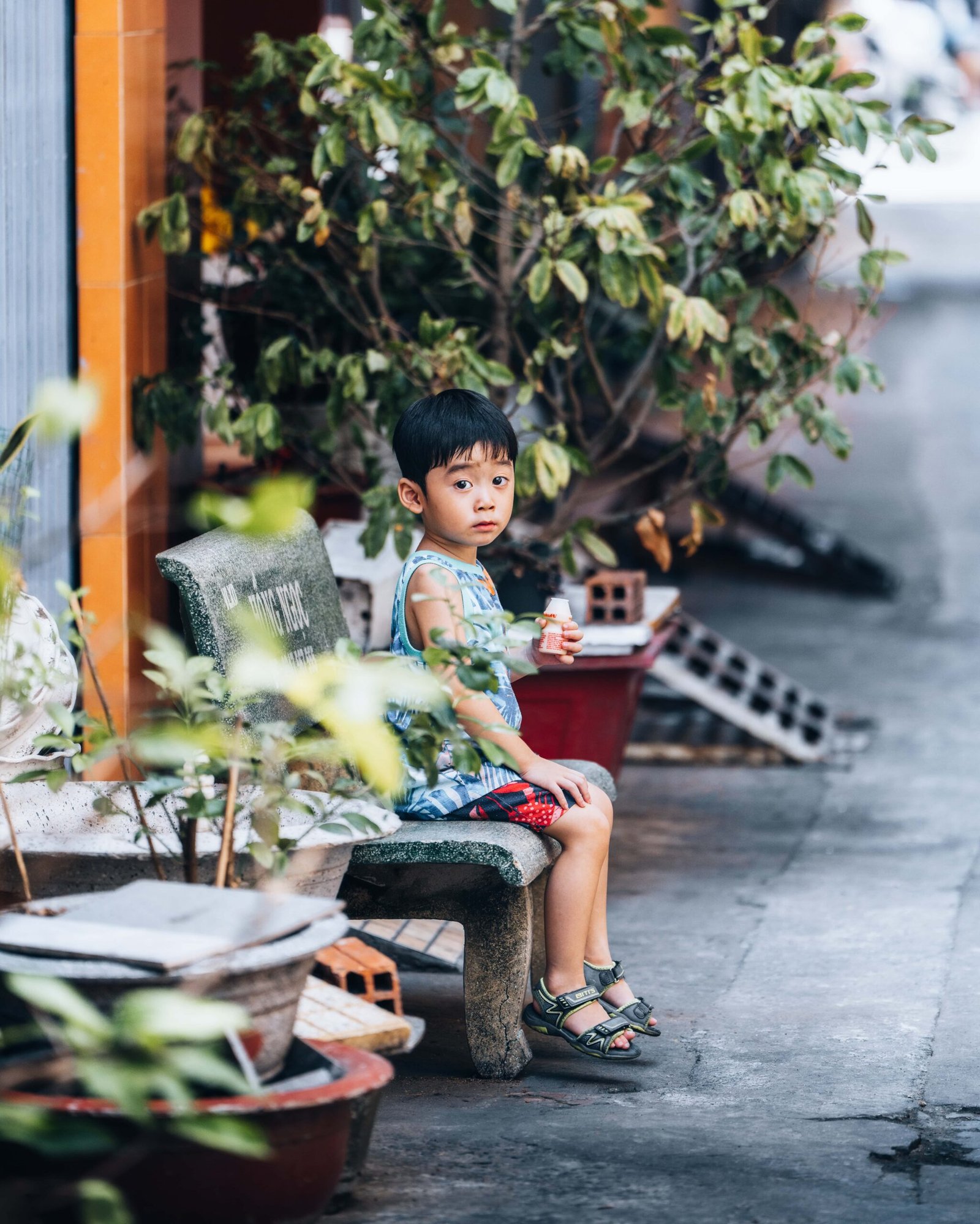 Little boy sitting on a bench in District 5, Saigon