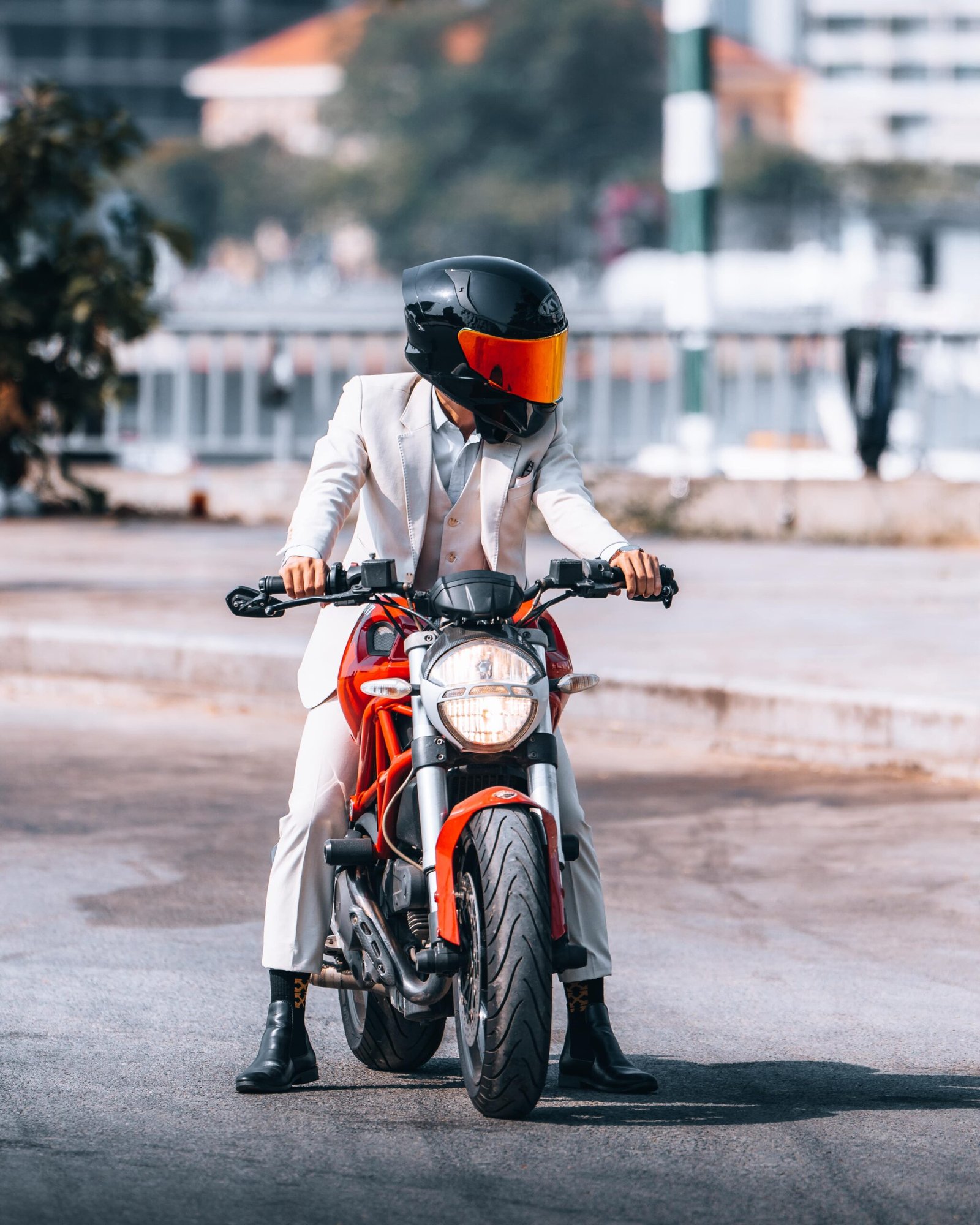 Man on a motorbike wearing a white suit
